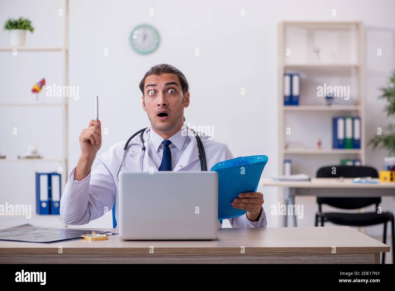 Young doctor taking notes at the hospital Stock Photo - Alamy
