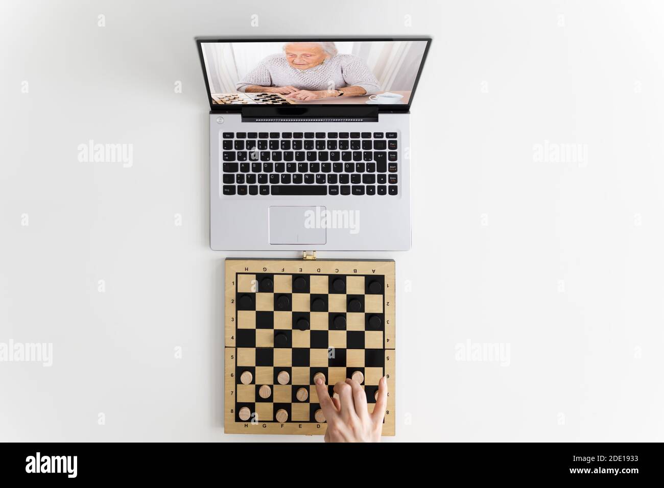 Woman Playing Checkers Online Using Video Conference Call Stock Photo