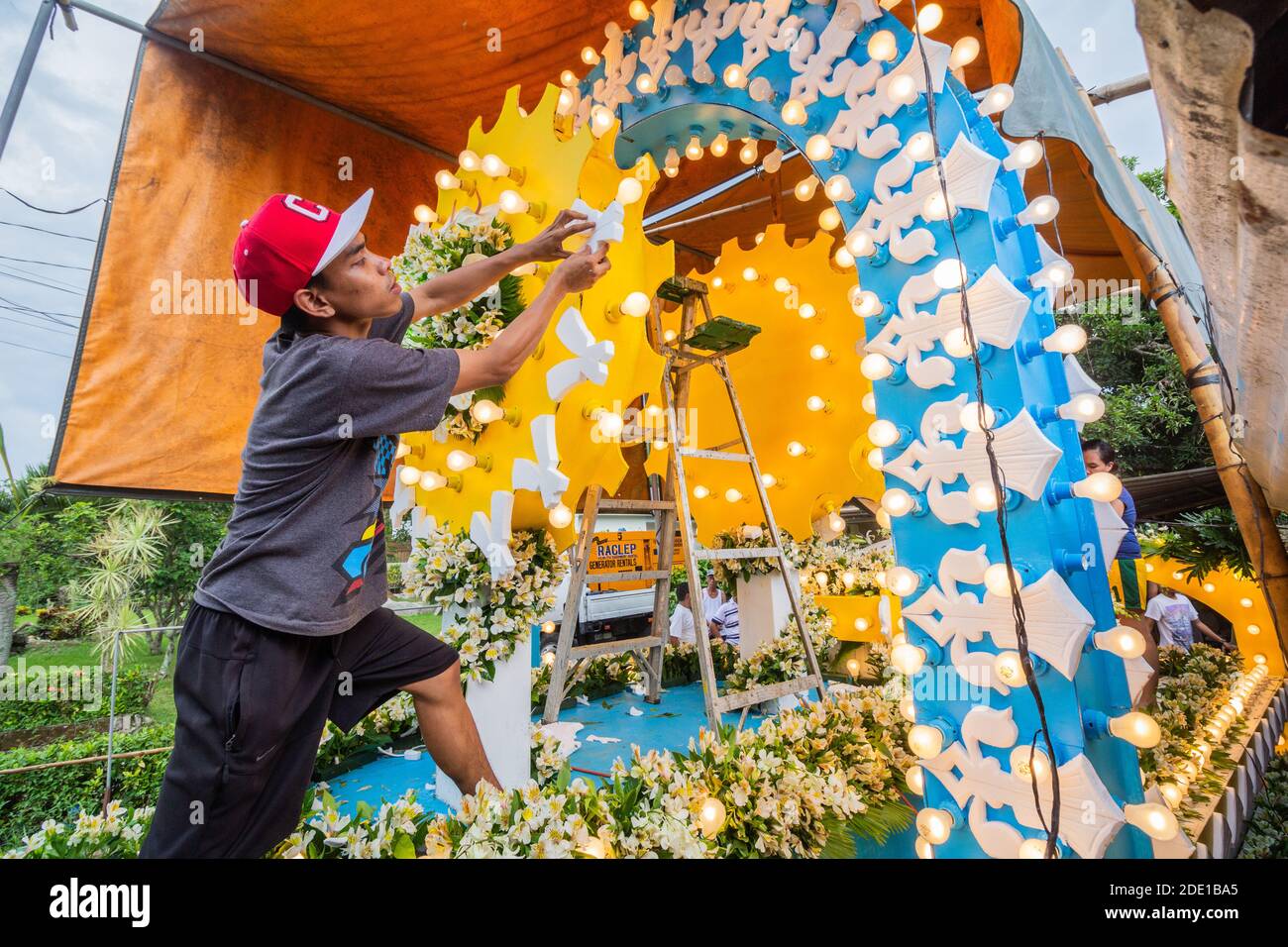 A Filipino man making finishing touches to a festival float to be used during the May Flower Tapusan Festival in Alitagtag, Batangas, Philippines Stock Photo