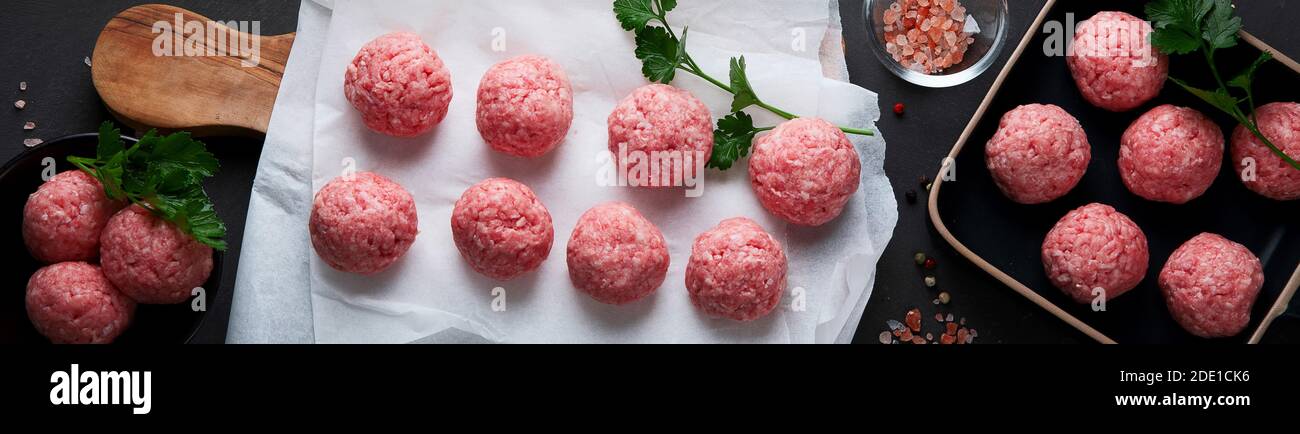 Fresh raw meatballs with herbs. Top view Stock Photo