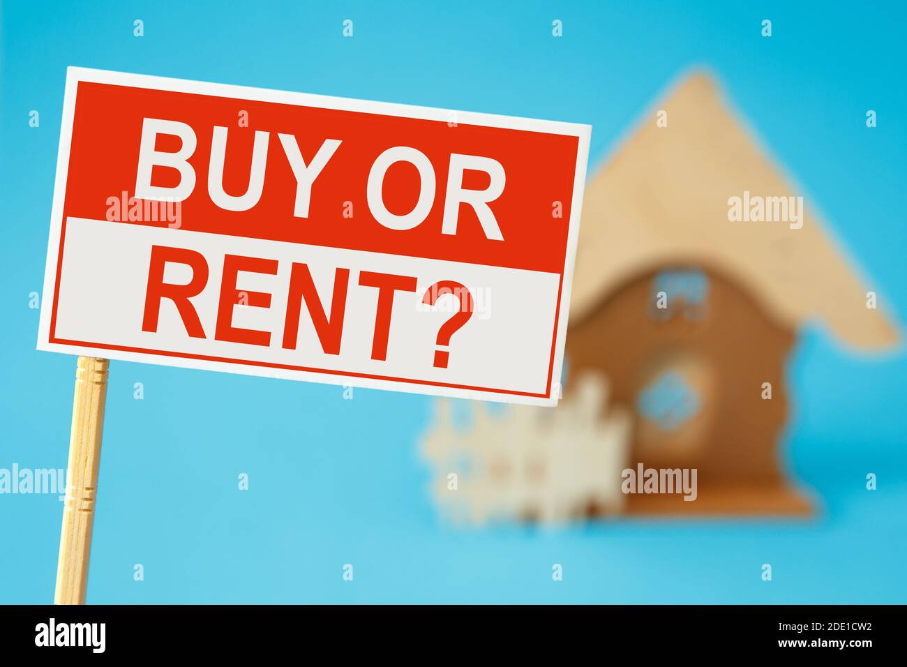 Sign board with text BUY OR RENT and house in background Stock Photo