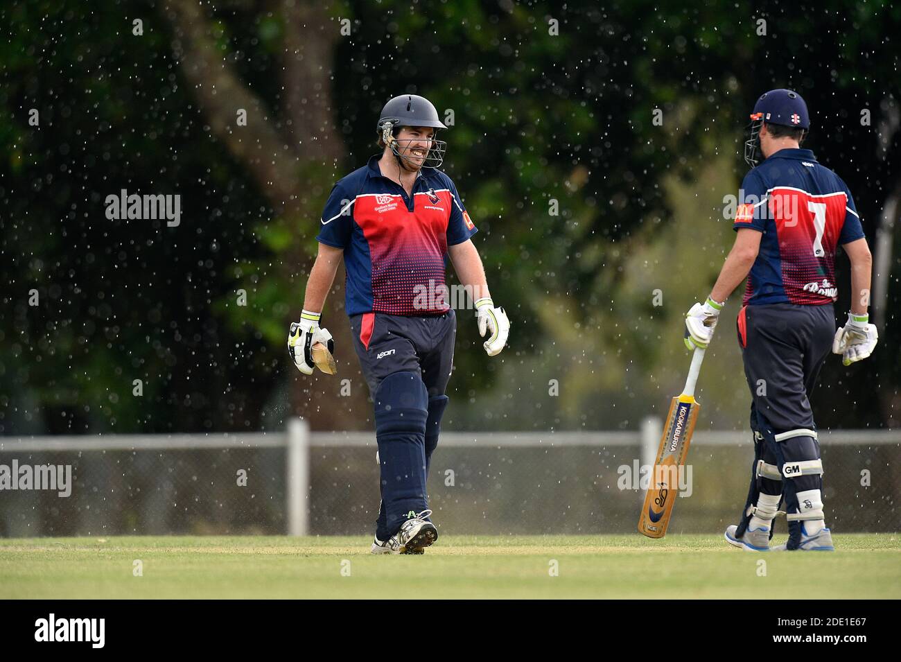 The Benalla Bushrangers take on Greta Cricket Club in a 20/20 game during bouts of heavy rain. Stock Photo