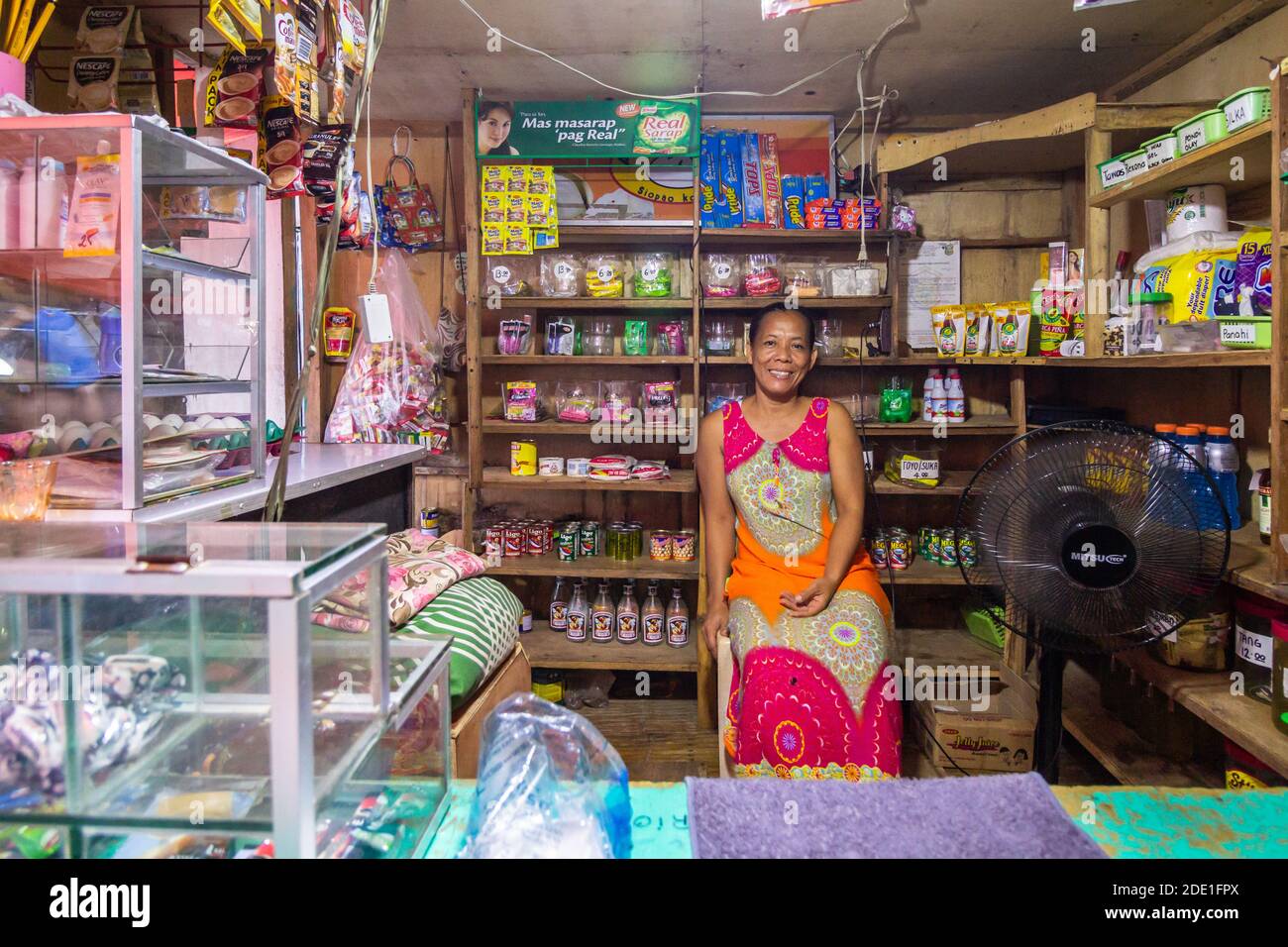 An owner smiling inside her home store locally called sari--sari store in Batangas, Philippines Stock Photo
