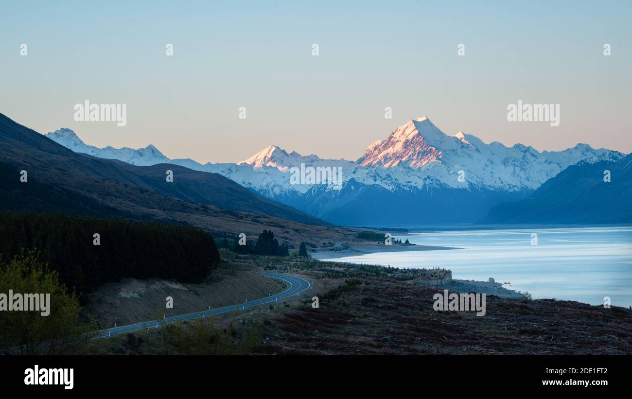 Aoraki/Mount Cook road and snow-capped mountains in the background along the shoreline of Lake Pukaki, South Island, New Zealand Stock Photo