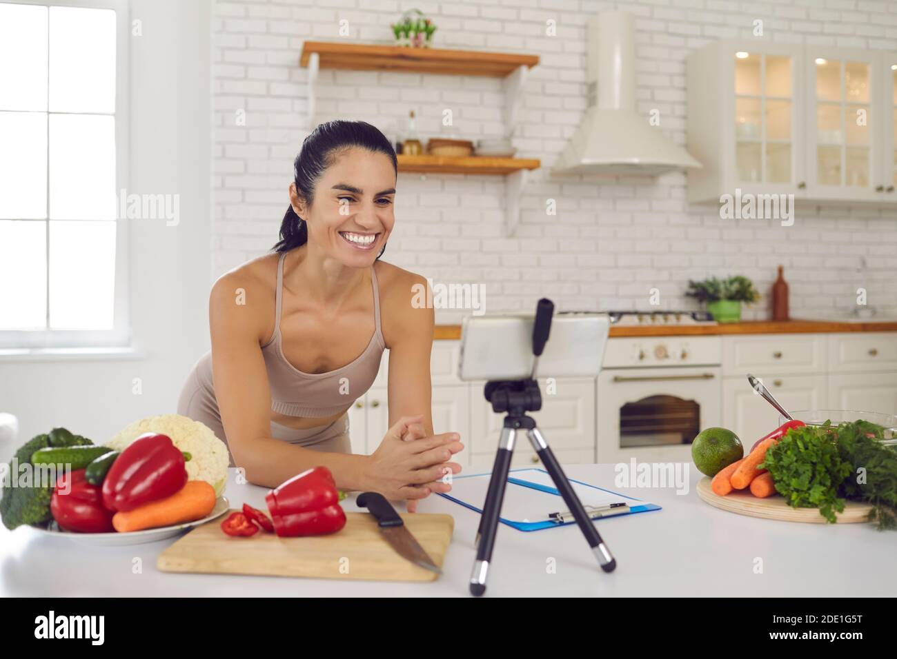 Smiling fitness vlogger recording video on vegetarian diet and healthy eating habits Stock Photo