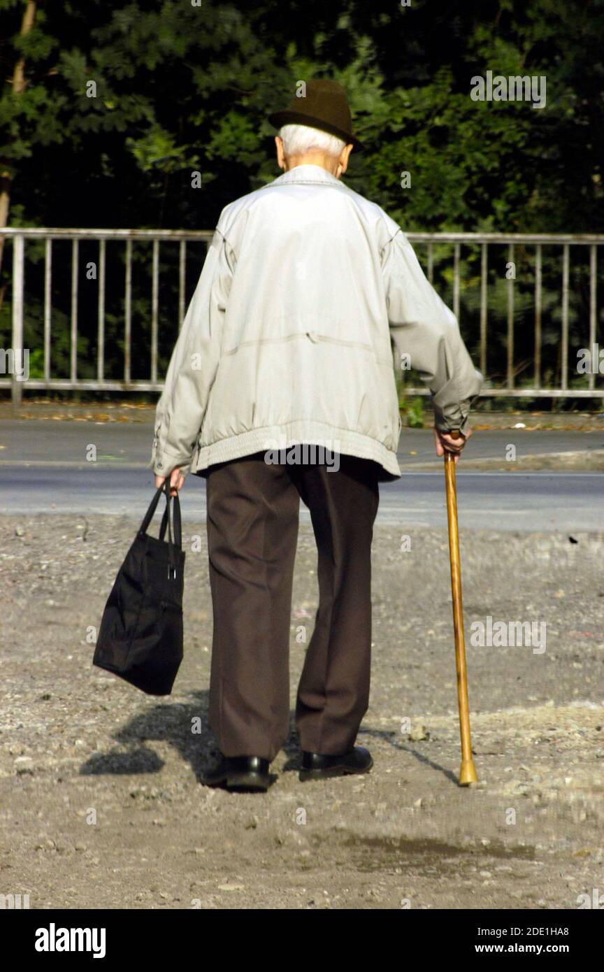 Old man with walking stick is walking on the streets Stock Photo - Alamy