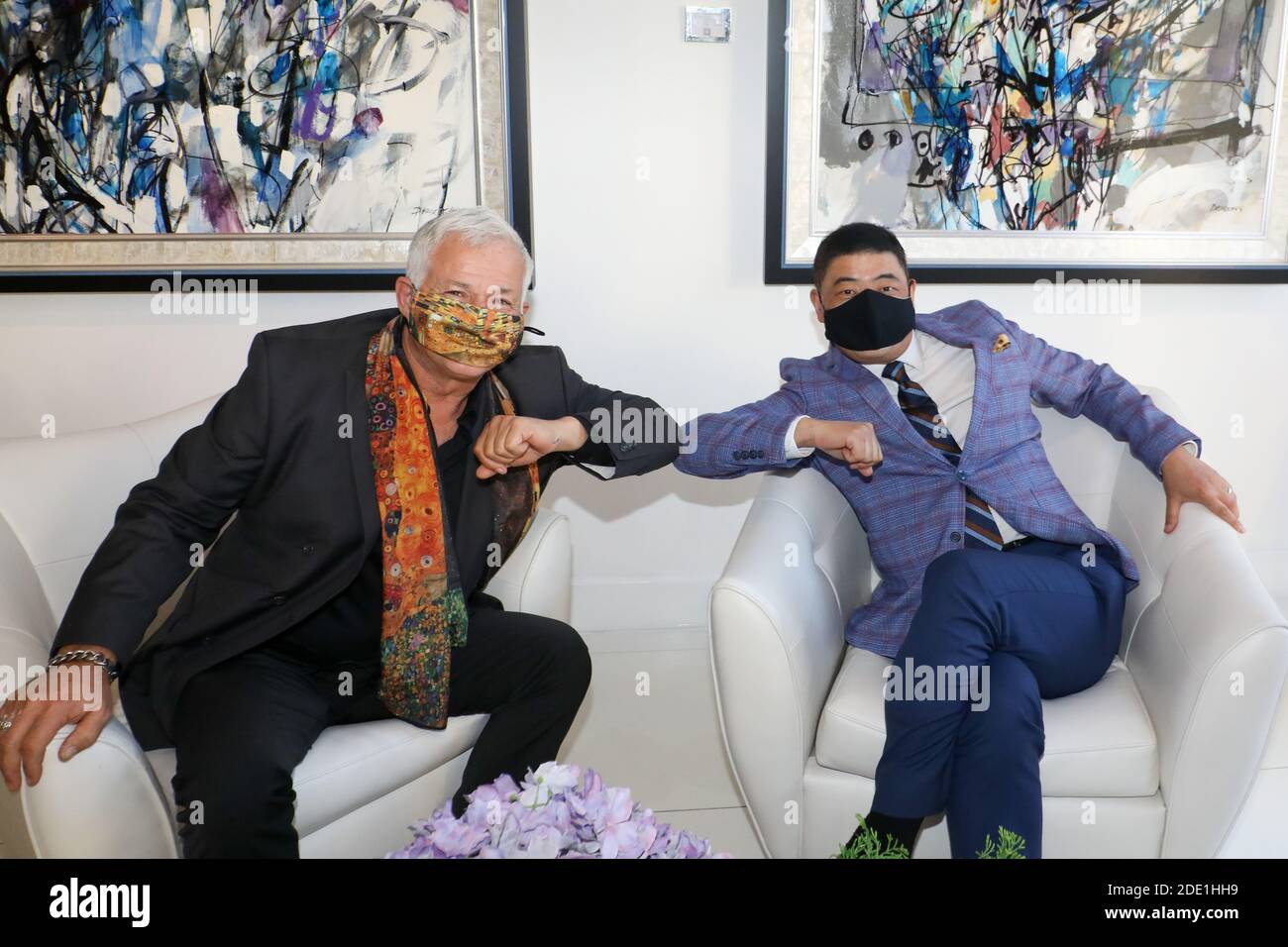 Beverly Hills, California.  27th November, 2020.  Art consultant /curator Michael Sean Degnan and TV Host Joey Zhou tap elbows wearing their masks during their interview for the Zhou Zheng Art Channel show at the Winn Slavin Fine Art Gallery in Beverly Hills.  Degnan is the Senior Art Advisor and Media Marketing Director for the Winn Slavin Fine Art Gallery,  Ambassador at Mondial Art Academia, and art consultant/curator in the art industry.  Joey Zhou is the host of the Zhou Zheng Art Channel and founder of the Los Angeles Beverly Arts (LABA) and The Beverly News. Credit:  Sheri Determan Stock Photo