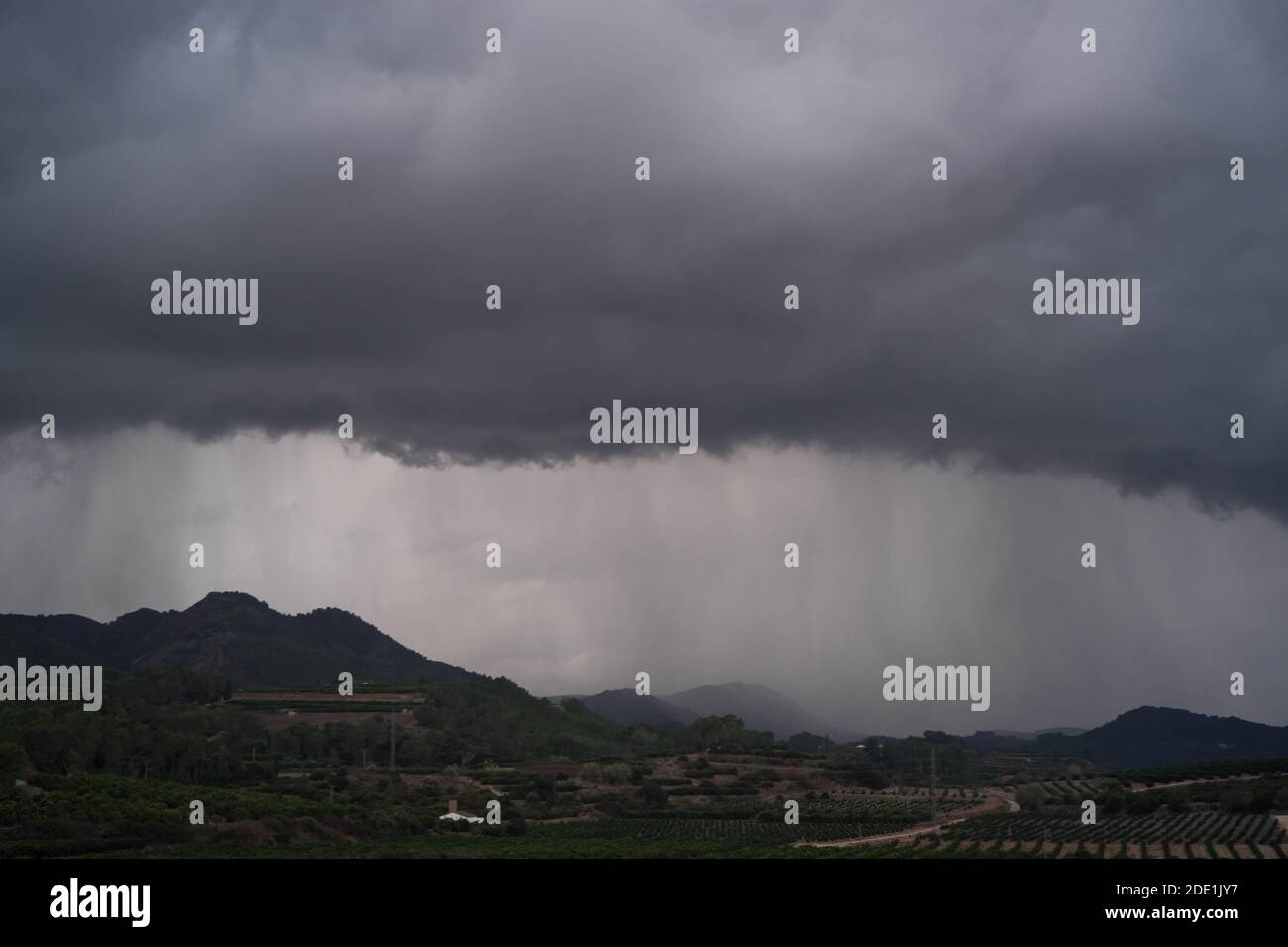 Heavy rainstorm rolling over Spanish countryside hills and valley Stock Photo