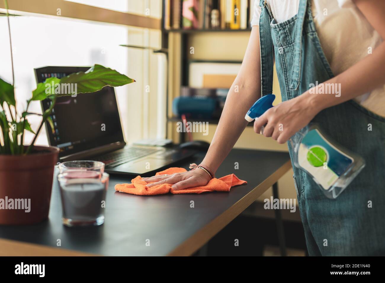 A Woman wipes dust with the cleaning cloth and uses antiseptic liquid