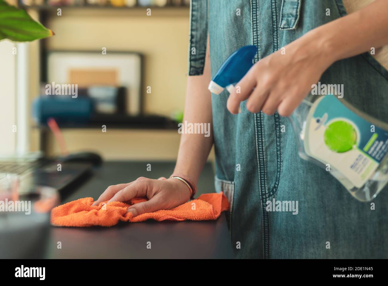 A Woman wipes dust with the cleaning cloth and uses antiseptic liquid