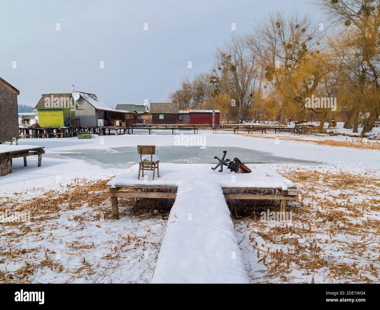 Abandoned fishing pier on frozen lake.View of the famous floating village at wintertime. Bokod,Hungary. Stock Photo