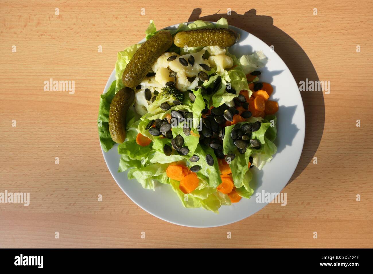 Vitamin bomb on the plate in the form of a mixed crisp salad with pumpkin seeds, from above Stock Photo