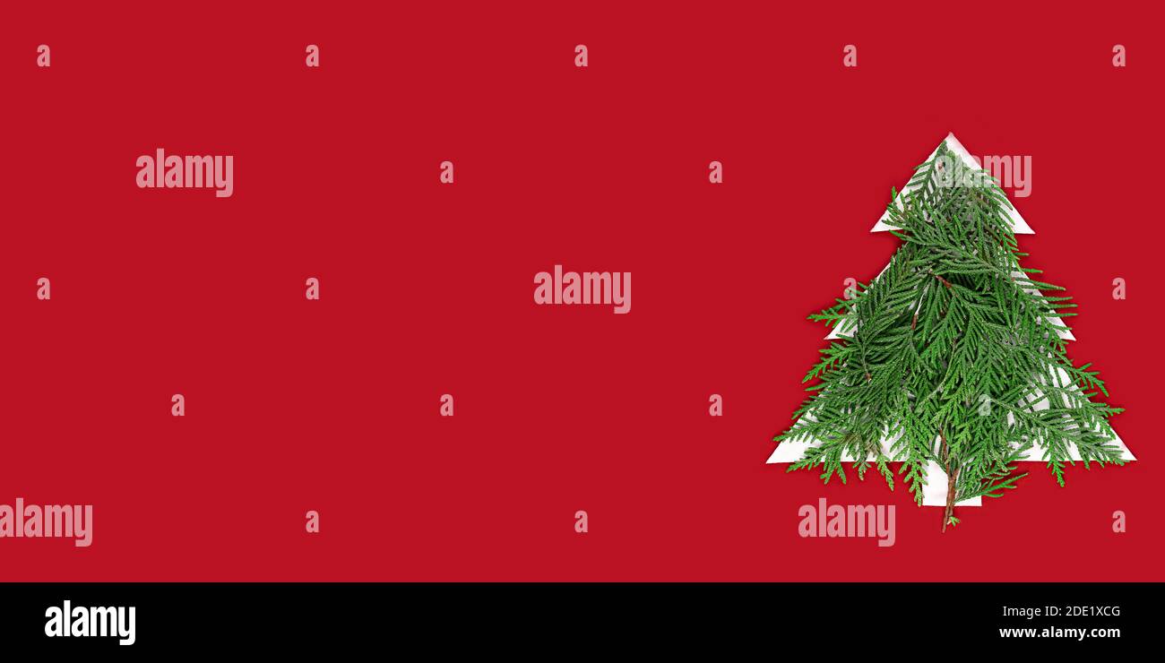Christmas tree cut out of paper on a red background. Silhouette of a ...