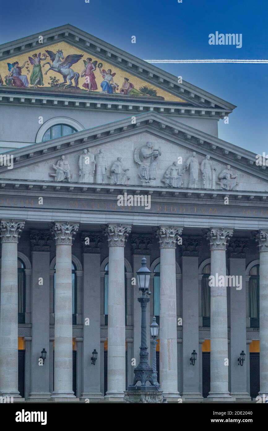 Close up of the front of the National Theatre, in Max-Joseph-Platz, Munich, designed by Karl von Fischer, with airplane vapour trail in the sky Stock Photo