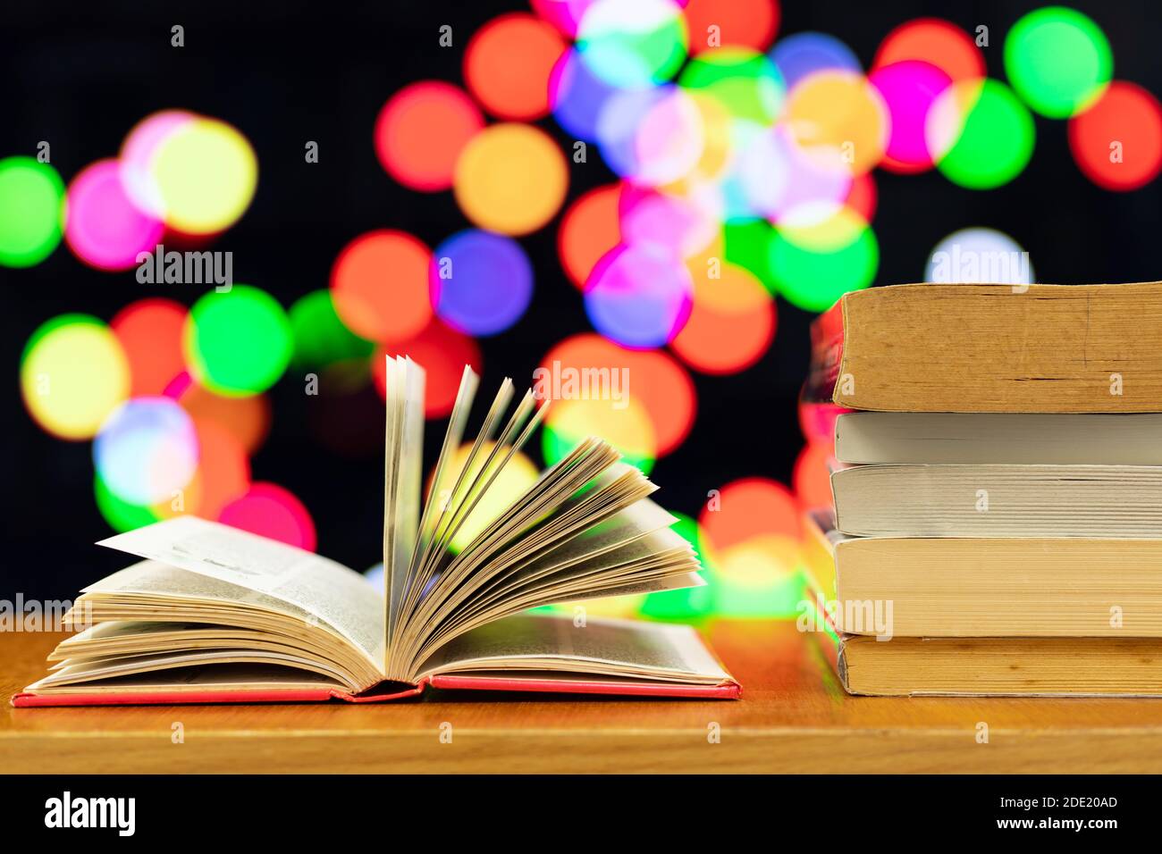 Một đống sách và cuốn sách mở với màu nền mờ nhạt làm nền sẽ mang đến cho bạn cảm giác ấm áp, yên bình khi đọc sách vào buổi tối. Cùng khám phá hình ảnh này để tìm thêm động lực đọc sách nhé. 