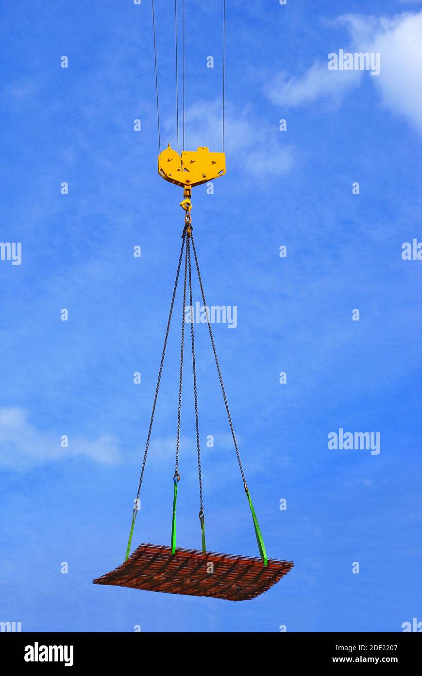Hanging a load on the end of a hoist by means of slings. Stock Photo