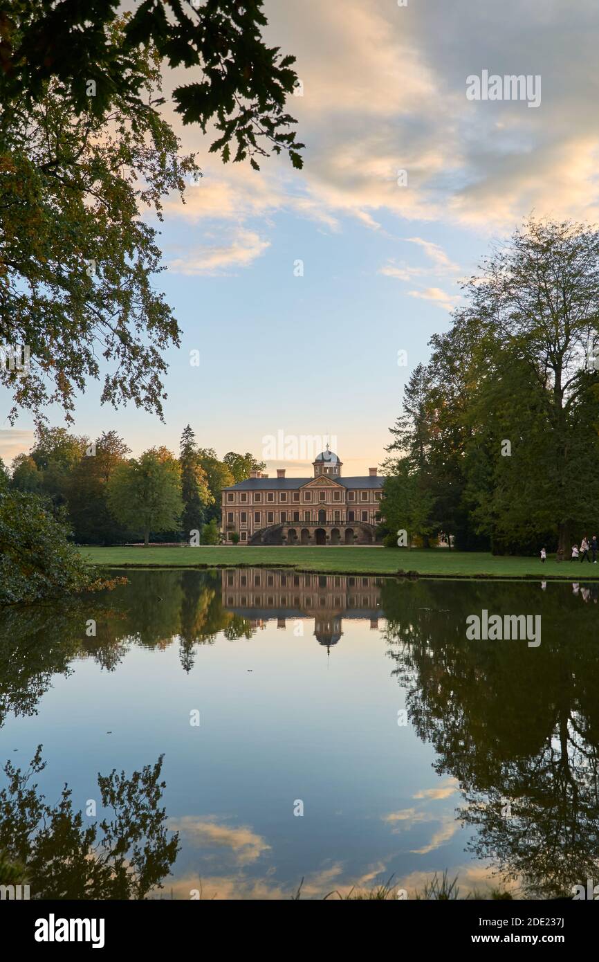 Rastatt Favorite Palace and idyllic palace garden with trees reflecting in pond at sunset Stock Photo