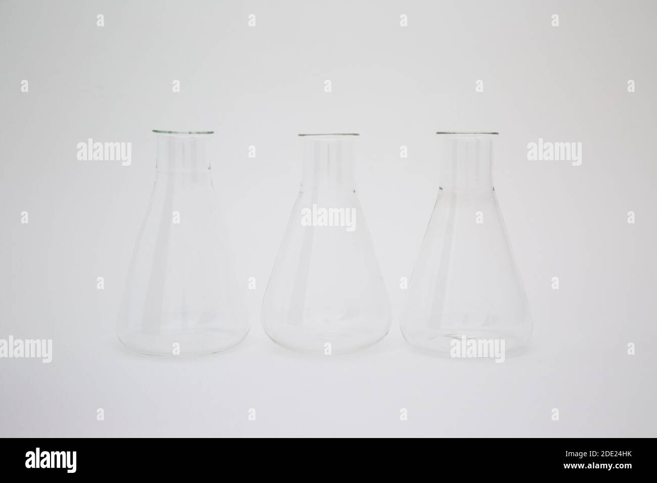 Three scientific laboratory glass erlenmeyer flask isolated on white