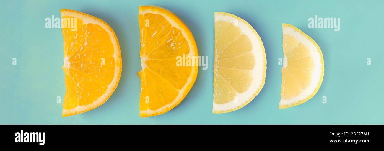 Lemon and orange slices arranged in a row on a pastel blue background ...