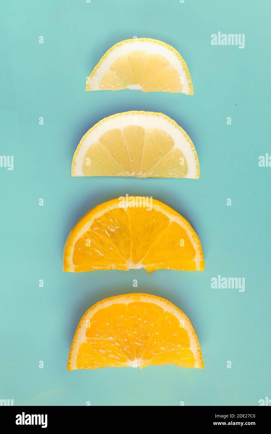 on a colorful blue paper background. Organic lemons and oranges. Stock Photo