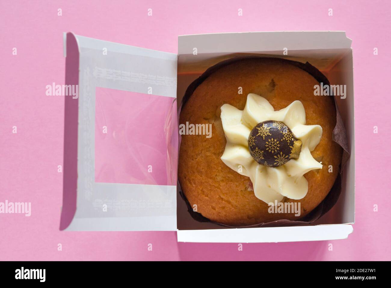 Christmas bauble muffin cake from M&S in-store bakery in box with lid open isolated on pink background - Bauble Victoria Sponge Muffin Stock Photo