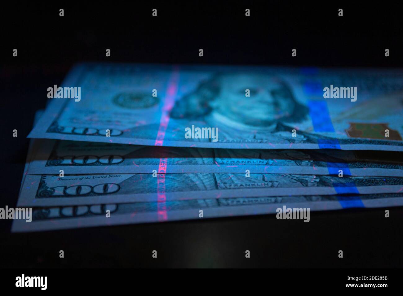 100 dollars banknot currency in UV light protection.Dollars in UV light