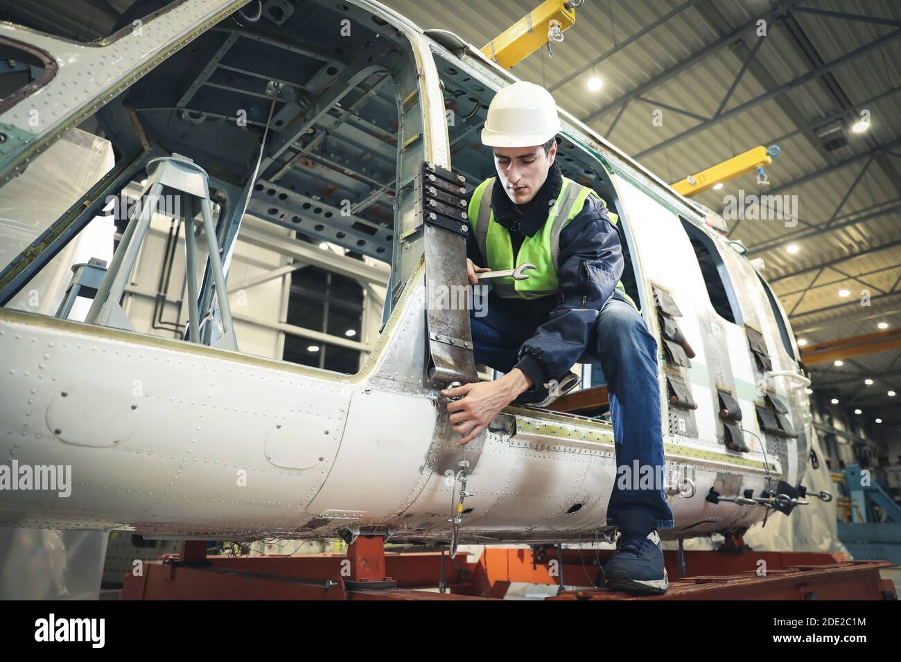 Portrait of a man , factory engineer in work clothes controlling the work process at the helicopter manufacturer. Stock Photo