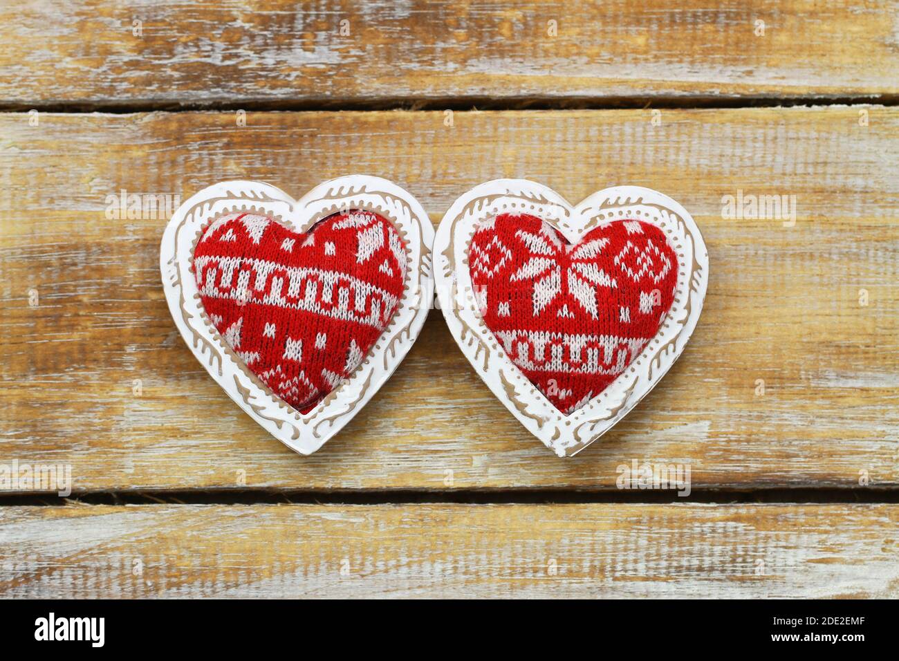 Two red knitted hearts on rustic wooden surface Stock Photo