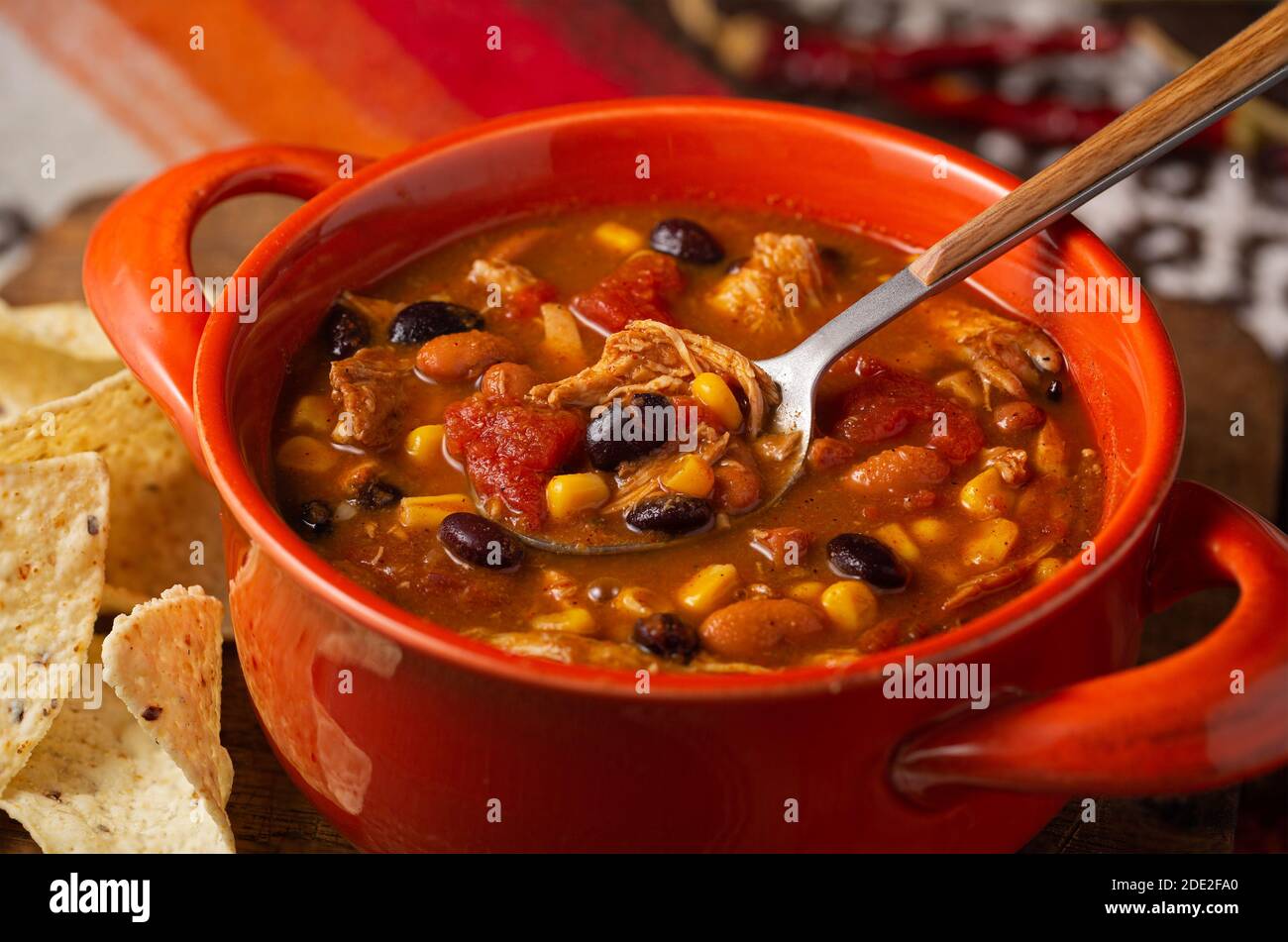 Wholesome taco chicken soup with warm tones served with tortilla chips Stock Photo