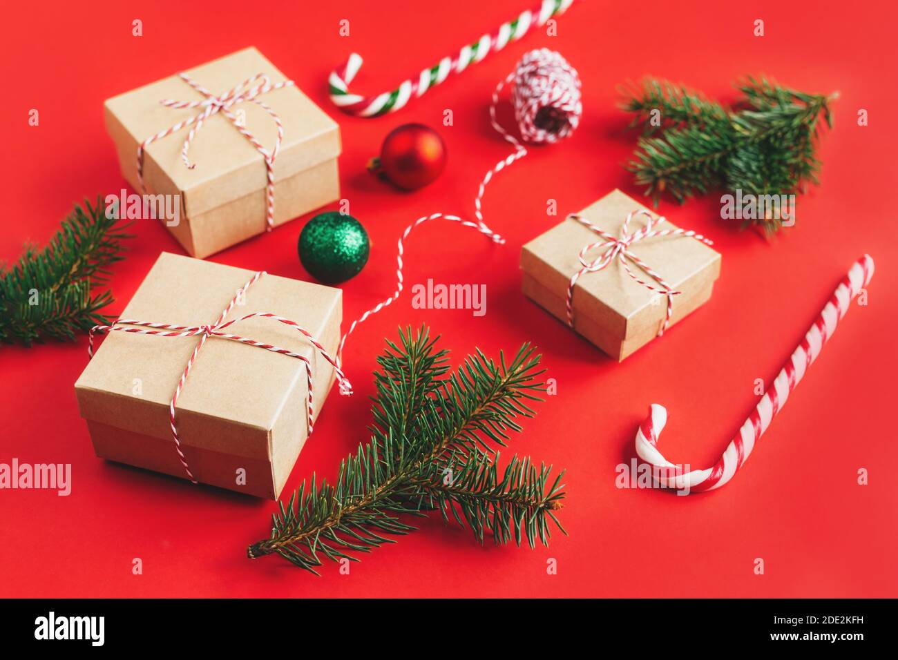 Craft gift boxes with spruce branches, balls and candy canes on a red ...