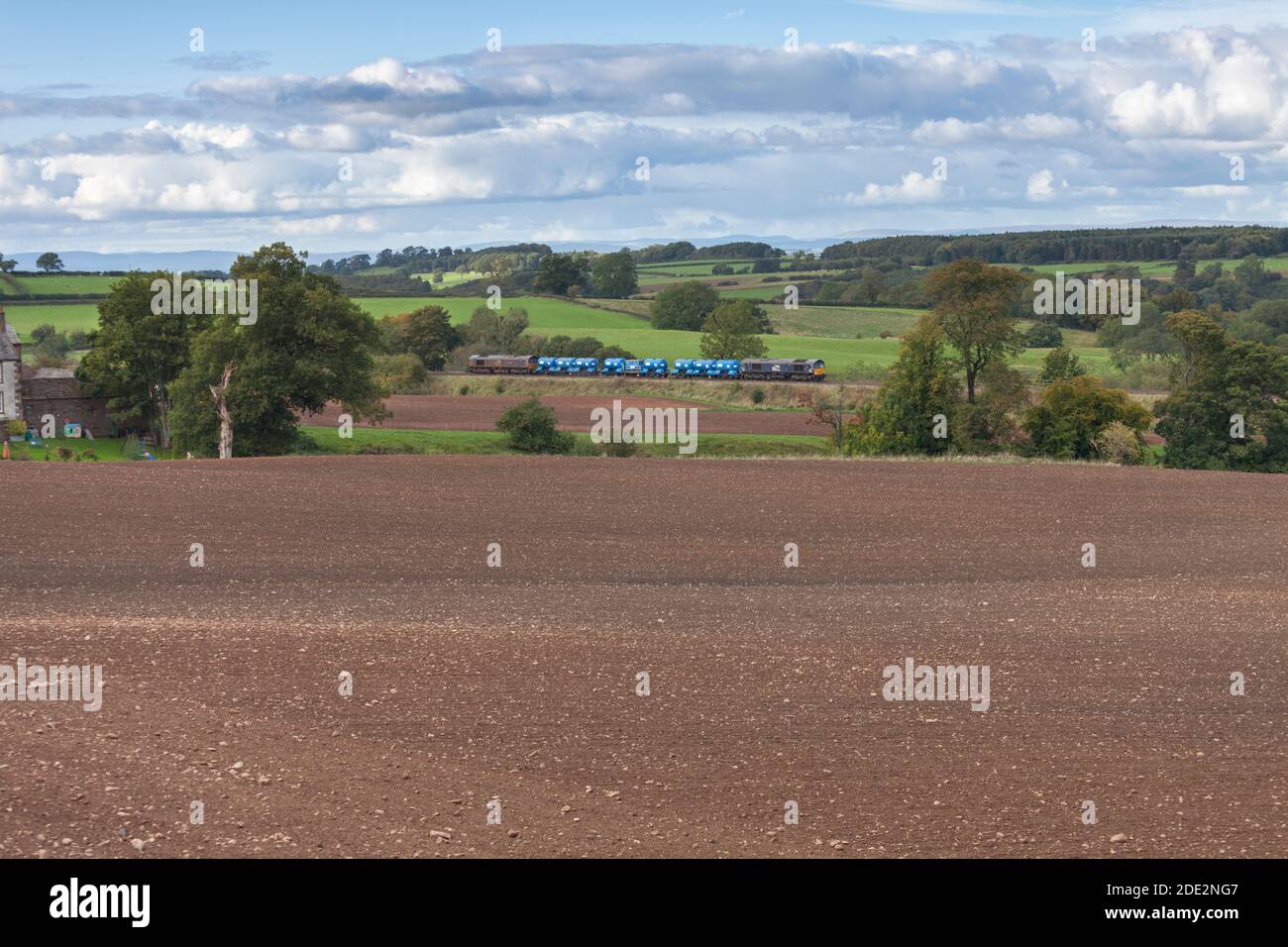 Direct Rail Services class 66 locomotives in the countryside with a Network Rail Railhead treatment train ( RHTT ) dealing with autumn leaves Stock Photo
