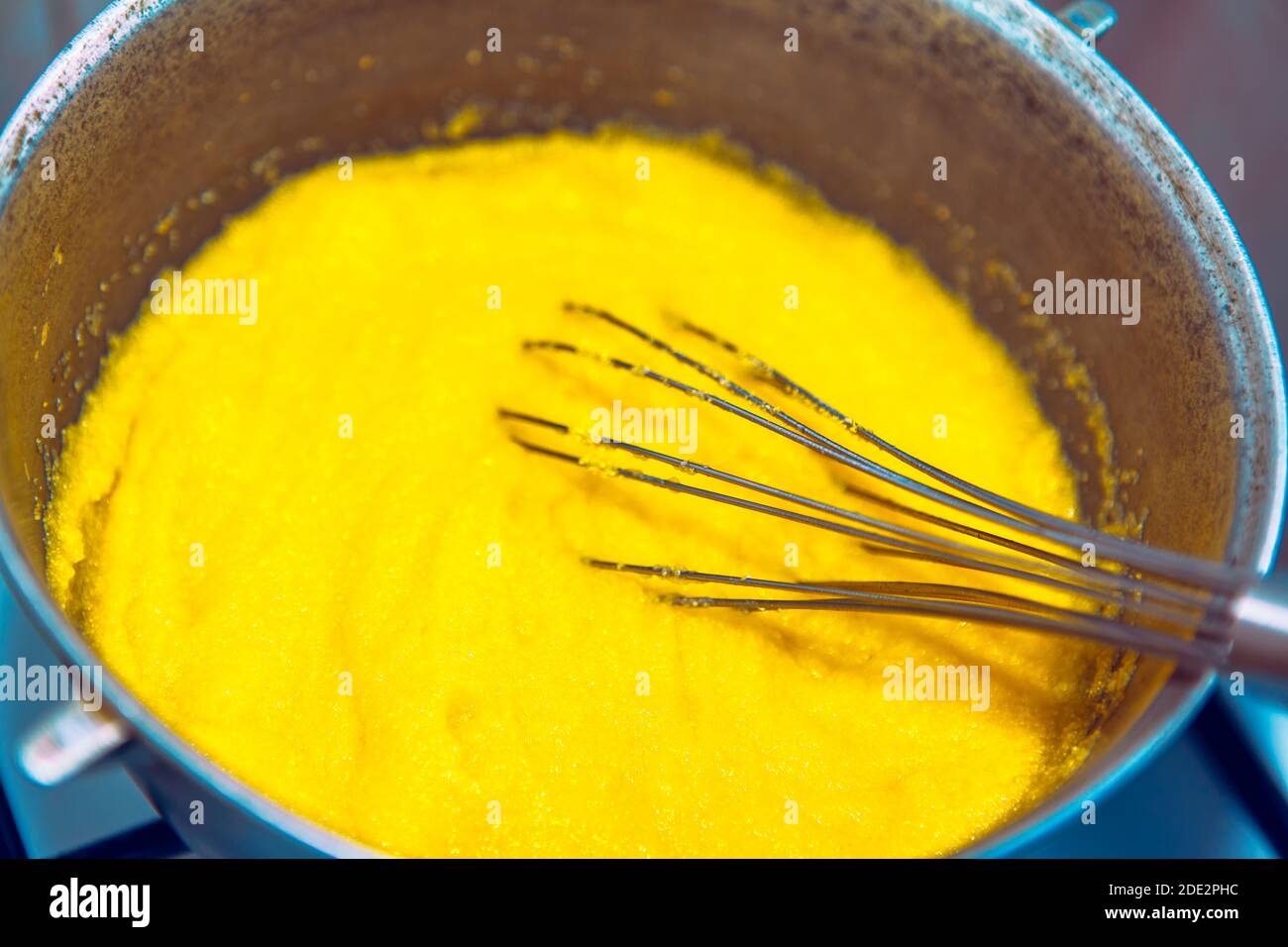 Preparing polenta in a cauldron . Romanian and Moldavian traditional food . Food made from corn flour Stock Photo