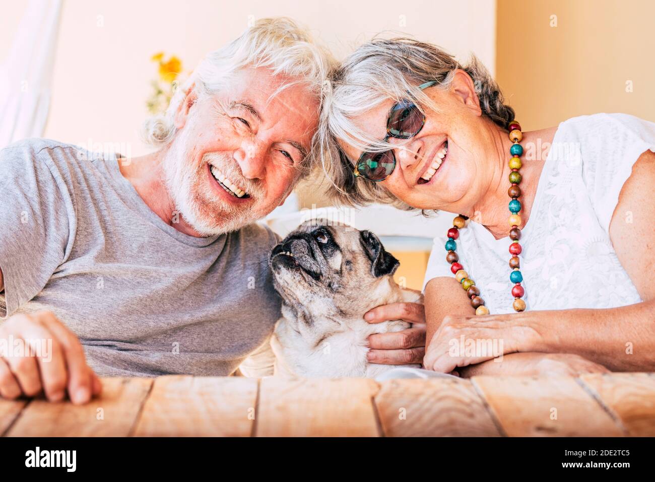 Cheerful old senior couple smile and enjoy her best friend dog pug with  love - concept of happy mature people and animal - joy retired elderly  lifesty Stock Photo - Alamy