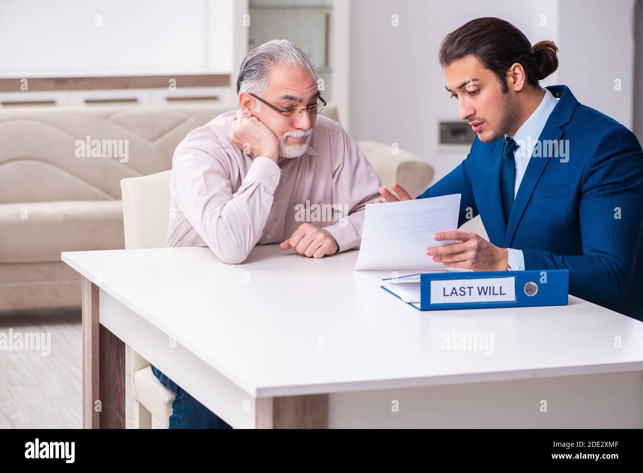Young lawyer visiting old man in testament concept Stock Photo Alamy