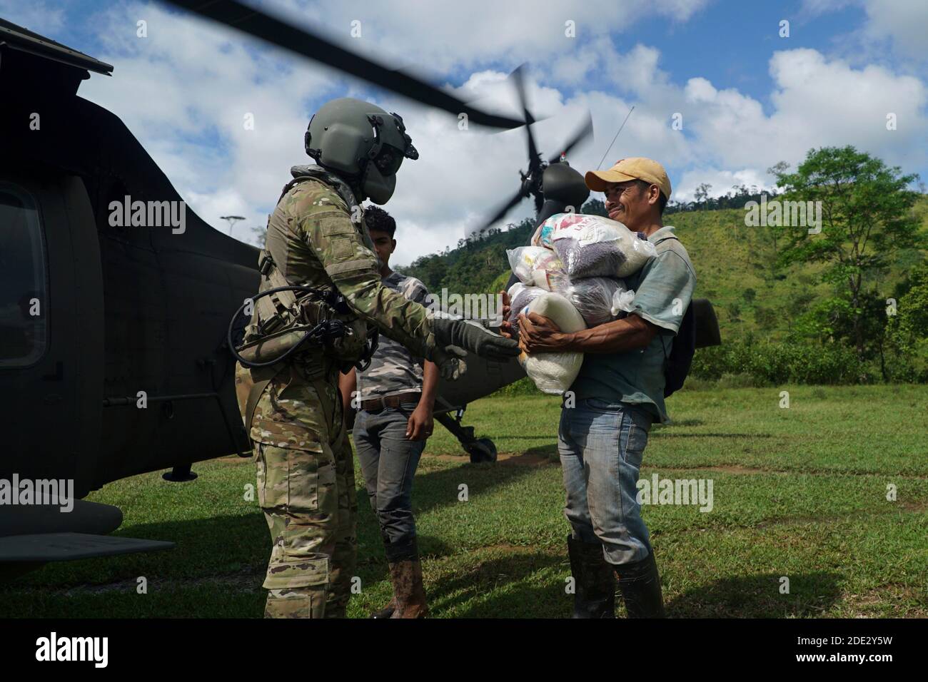 A U.S. soldier unloads humanitarian aid from a UH-60 Black Hawk helicopter to a resident stranded by Hurricane Iota November 27, 2020 in North Eastern, Honduras. Hurricane Iota swept through Central America destroying large sections of the coast and flooding roads. Stock Photo