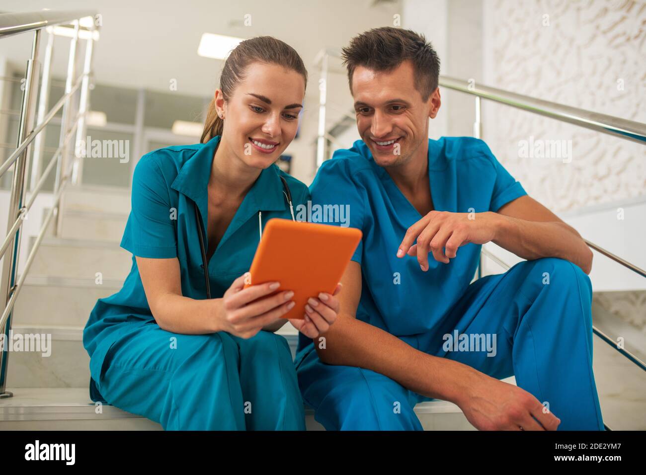 Two medical workers watching something on internet and discussing Stock Photo