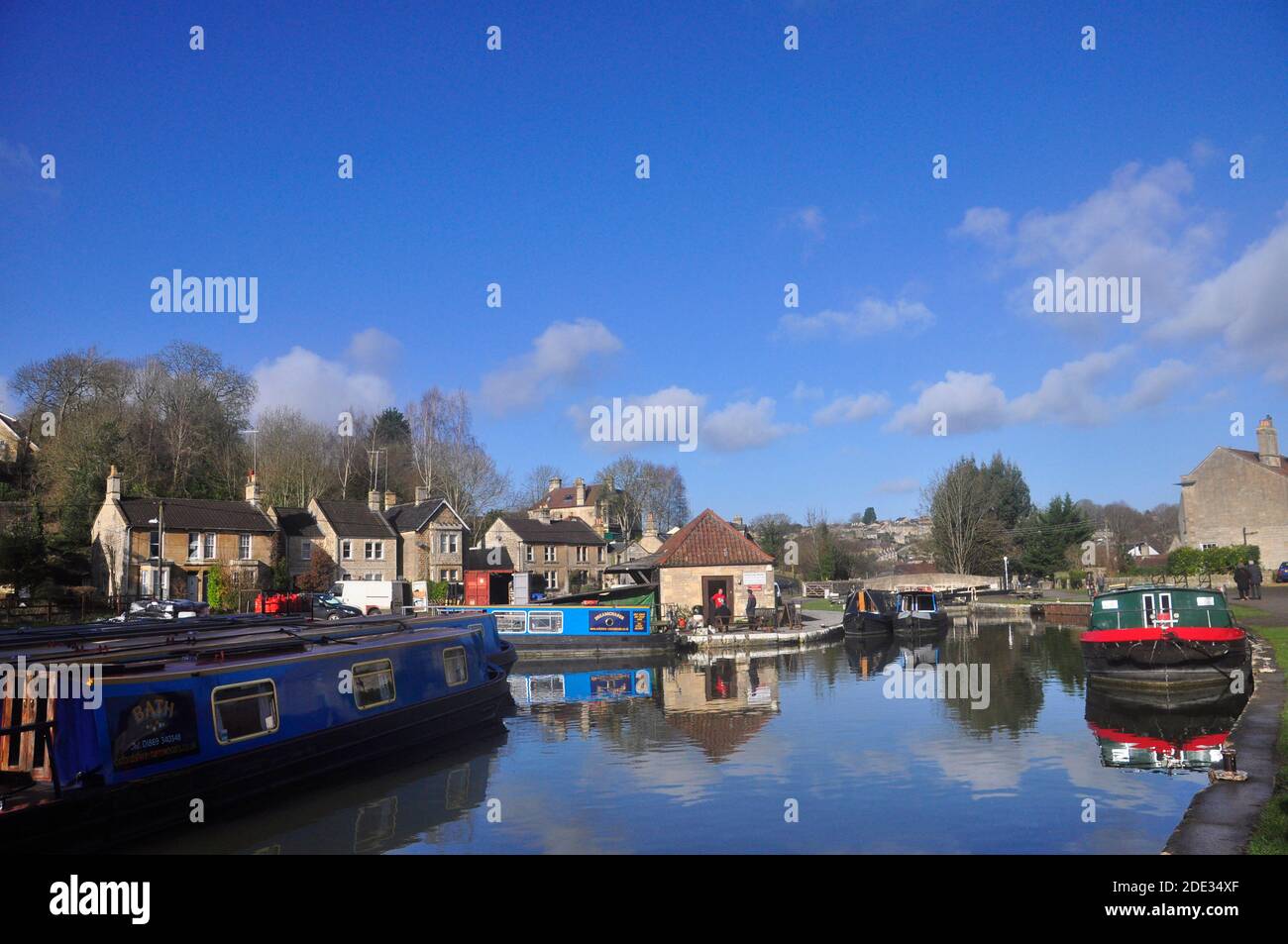 The basin above the lock on the Kennet and Avon canal at Bradford on Avon.Longboats reflected in the canal on a bright winter day.Wiltshire.UK Stock Photo