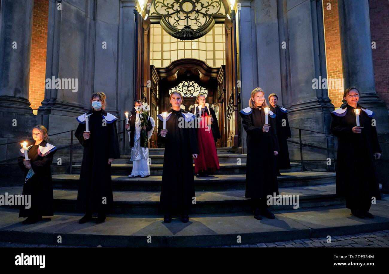 Hamburg, Germany. 28th Nov, 2020. Singers of a choir sing 'Singen-Hören-Staunen' on the church square in front of the Michaeliskirche after the Advent service. Credit: Axel Heimken/dpa/Alamy Live News Stock Photo