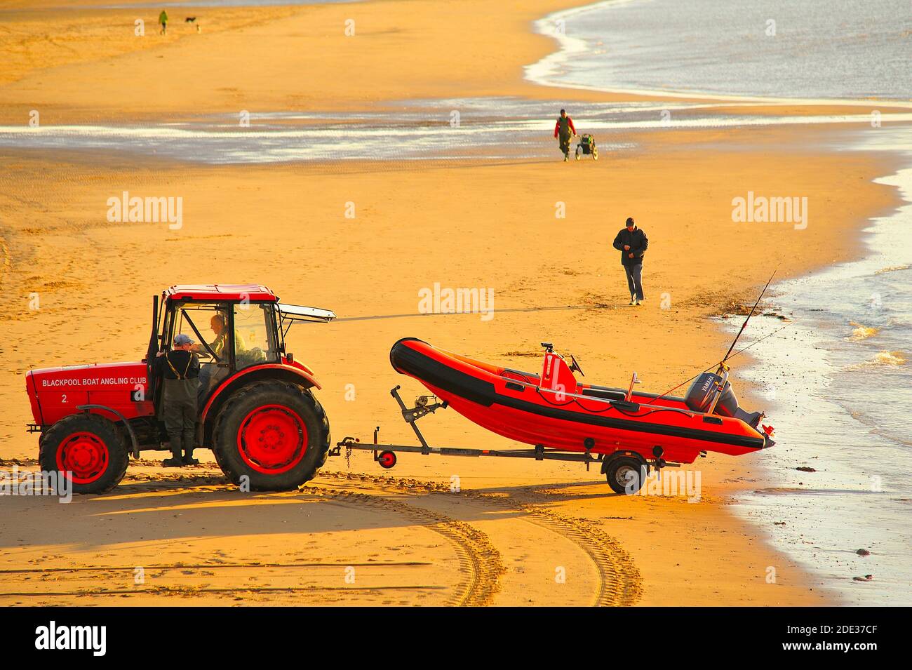 Red tractor launching red speed boat off St Annes beach Stock Photo