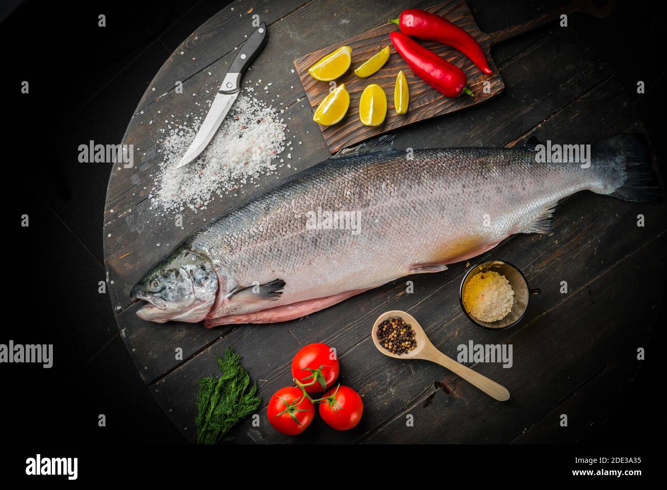 Big fresh salmon with ingredients for cooking on wooden background  Stock Photo