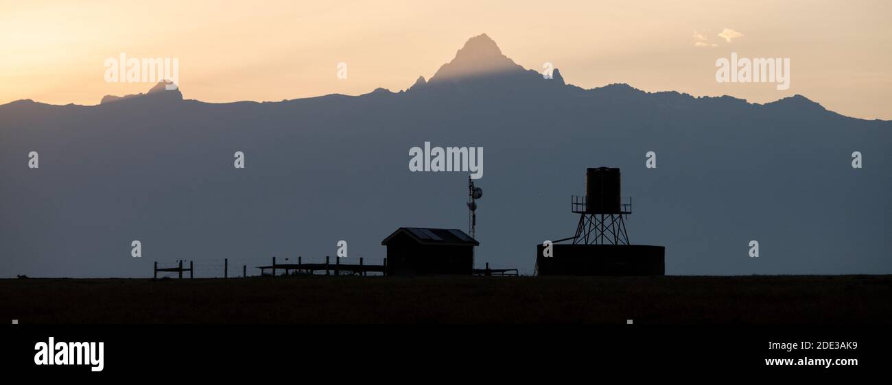 Africa, Kenya, Laikipia Plateau, Ol Pejeta Conservancy. Mount Kenya sunrise, highest mountain in Kenya, 17,057 ft. UNESCO. Cattle station silhouette. Stock Photo