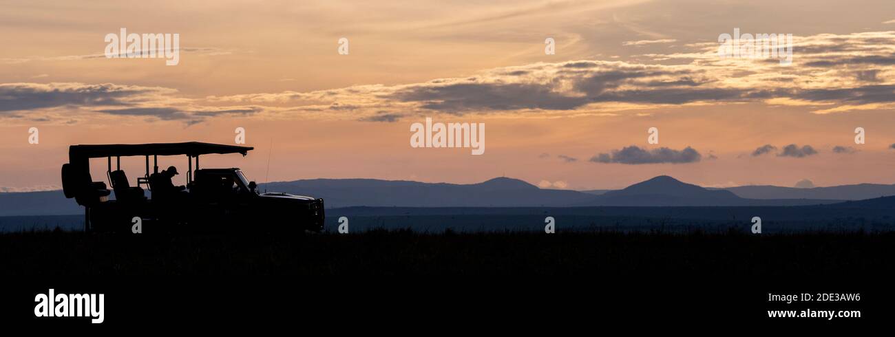 Africa, Kenya, Northern Serengeti Plains, Maasai Mara. Mara sunrise with safari jeep silhouette. Stock Photo