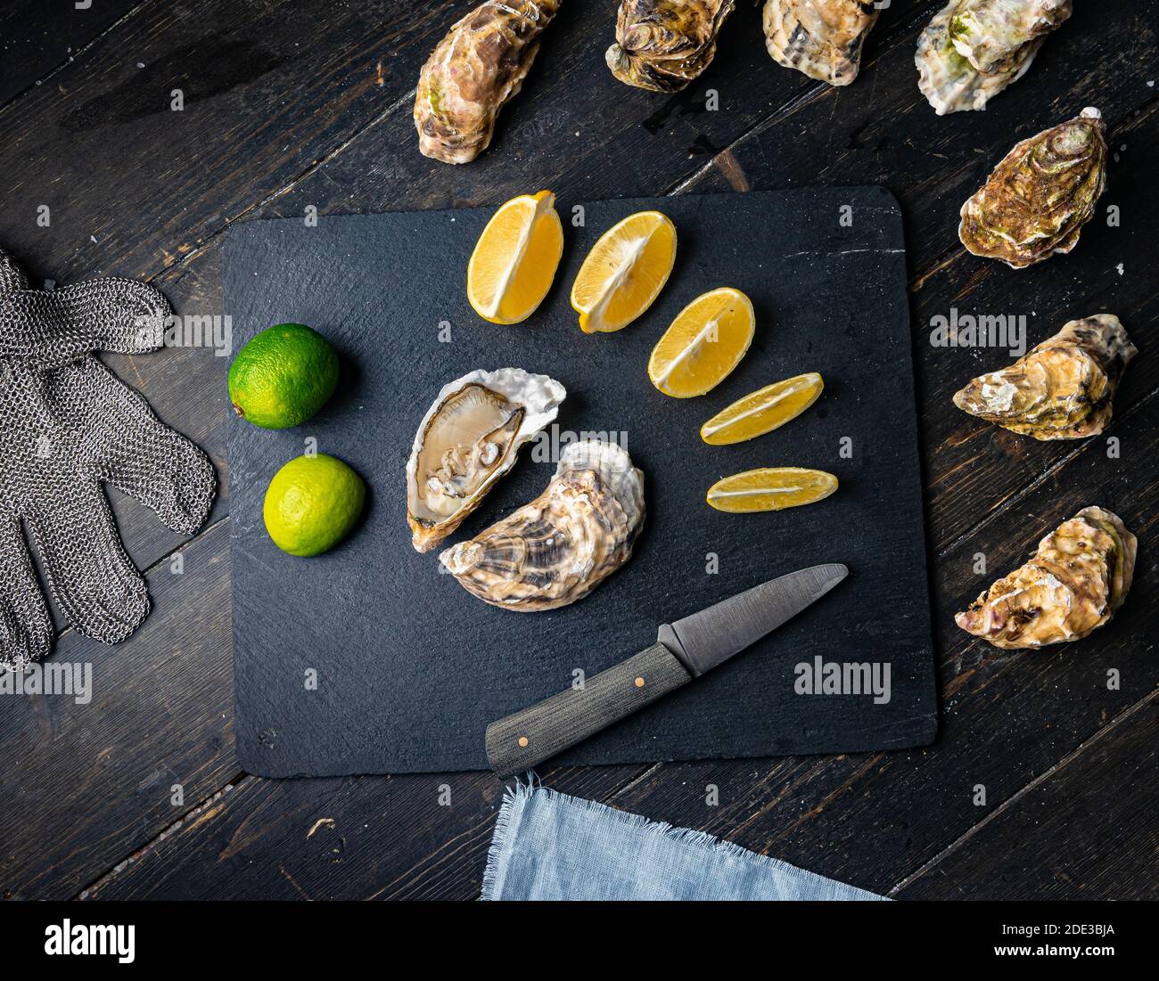 Fresh oysters on a black stone background. Top view. Oyster dinner in