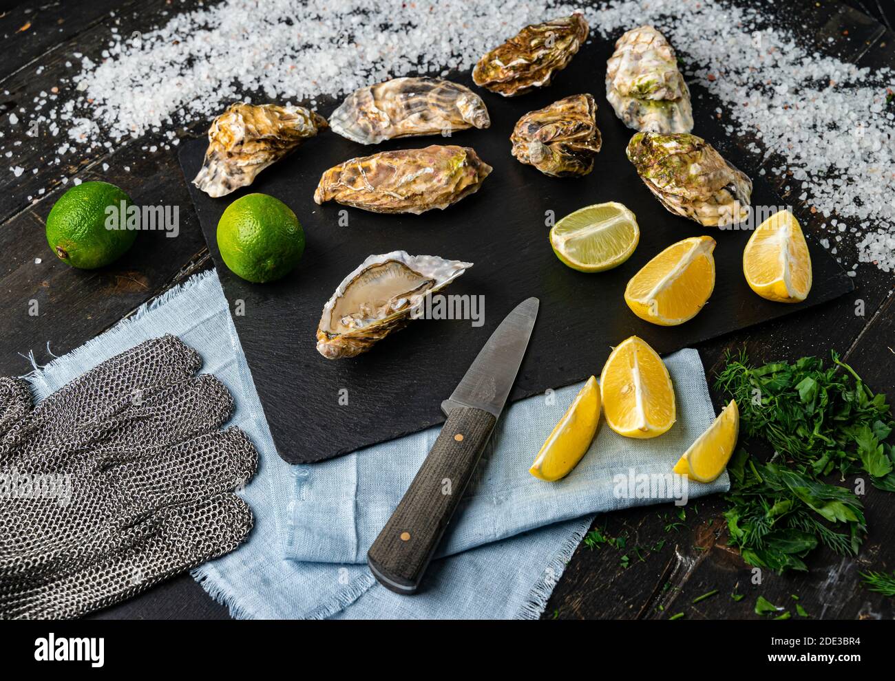 Fresh oysters on a black stone background. Top view. Oyster dinner in