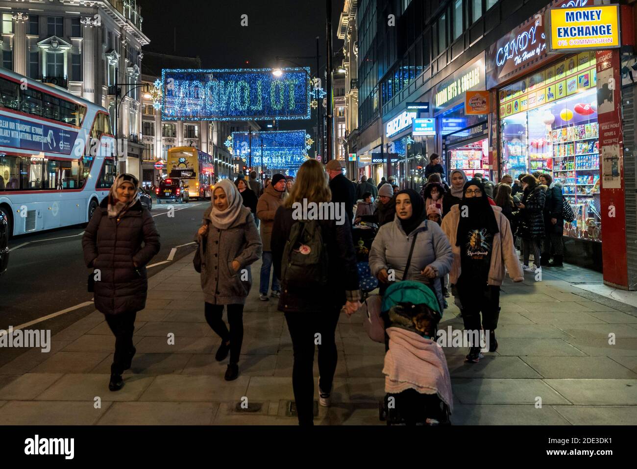 London, UK.  28 November 2020.   A surprisingly large number of people pass by in Oxford Street in the West End on the Saturday evening of the weekend before England comes out of coronavirus pandemic lockdown on 2 December.   A regional tier alert level system is in place after that in the run up to Christmas.  Credit: Stephen Chung / Alamy Live News Stock Photo