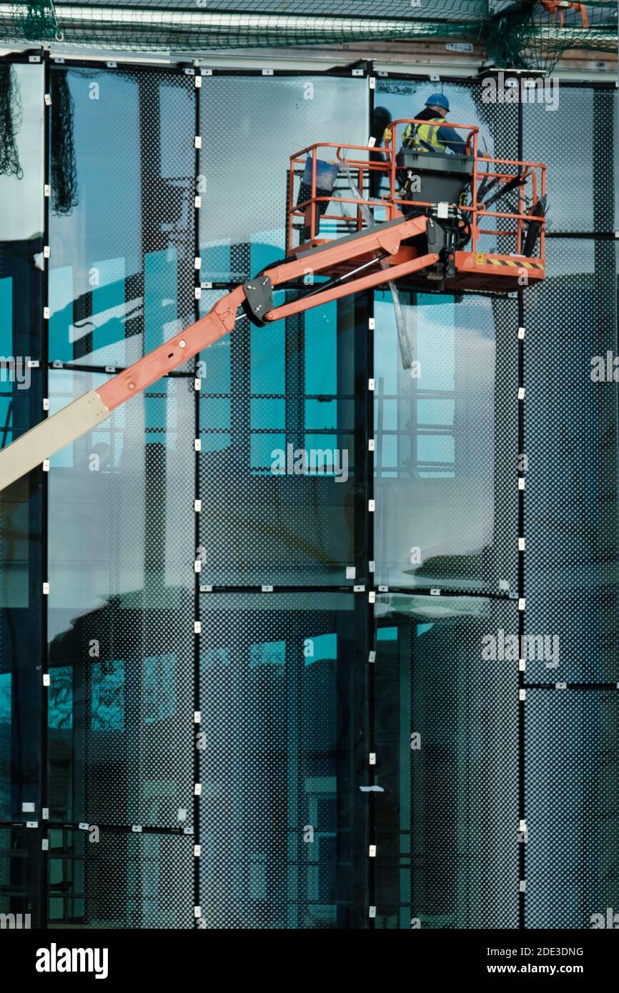 A glazier working at heights on a construction site at the University of Central Lancashire in Preston Stock Photo