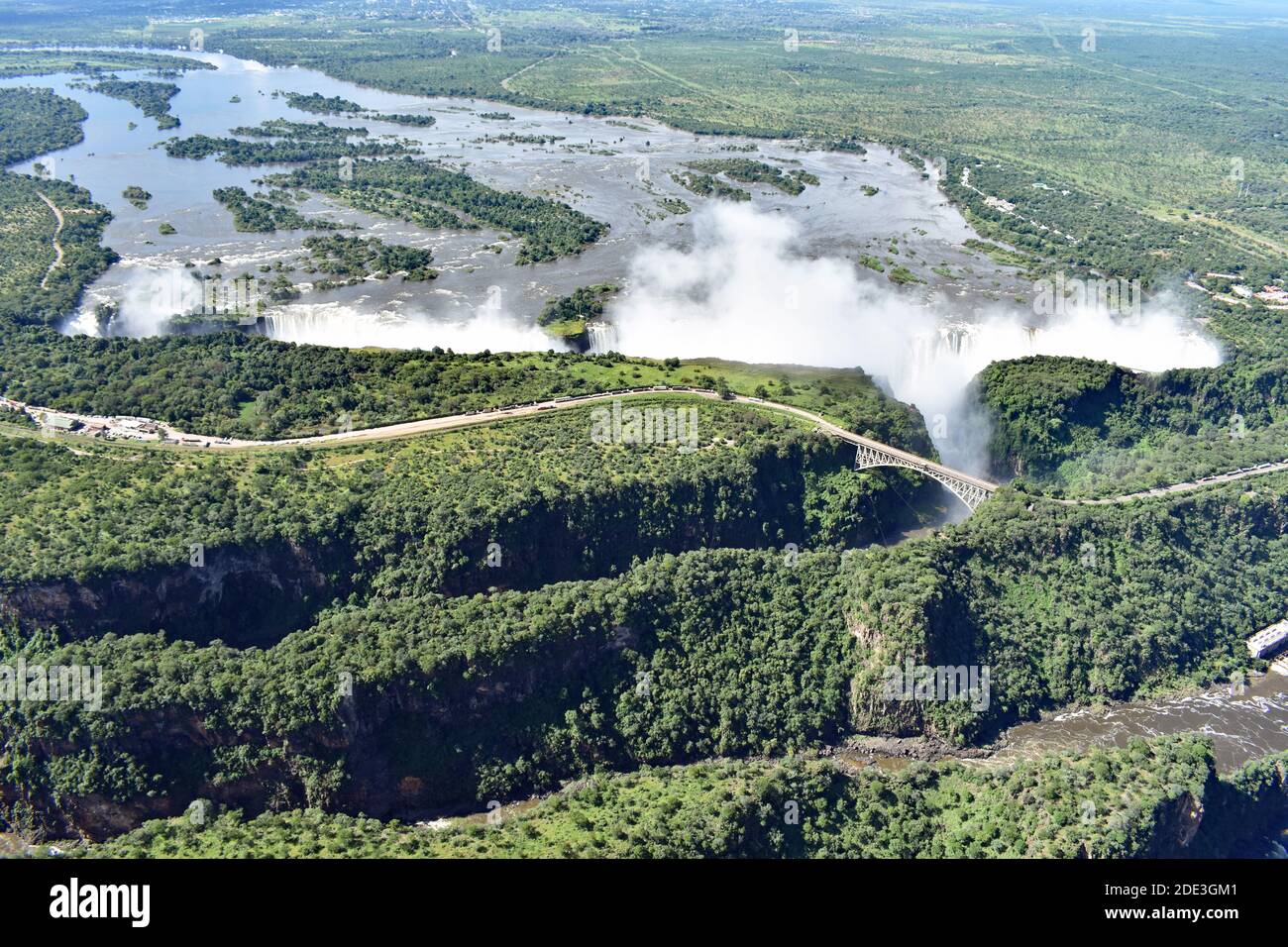 An aerial view of The Smoke That Thunders, Victoria Falls Bridge and the gorges.  Spray rises from the waterfall.  Zimbabwe and Zambia, Africa. Stock Photo