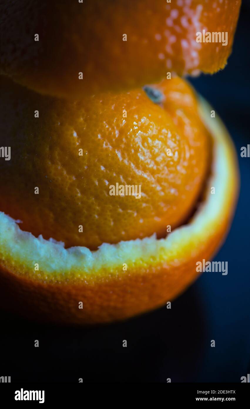 Still life of an orange wrapped in orange peel Stock Photo