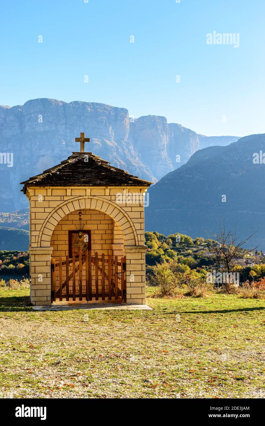 Traditional architecture of  a stone building with mountains of Pindus as a background   during  fall season in Ioannina Greece Stock Photo
