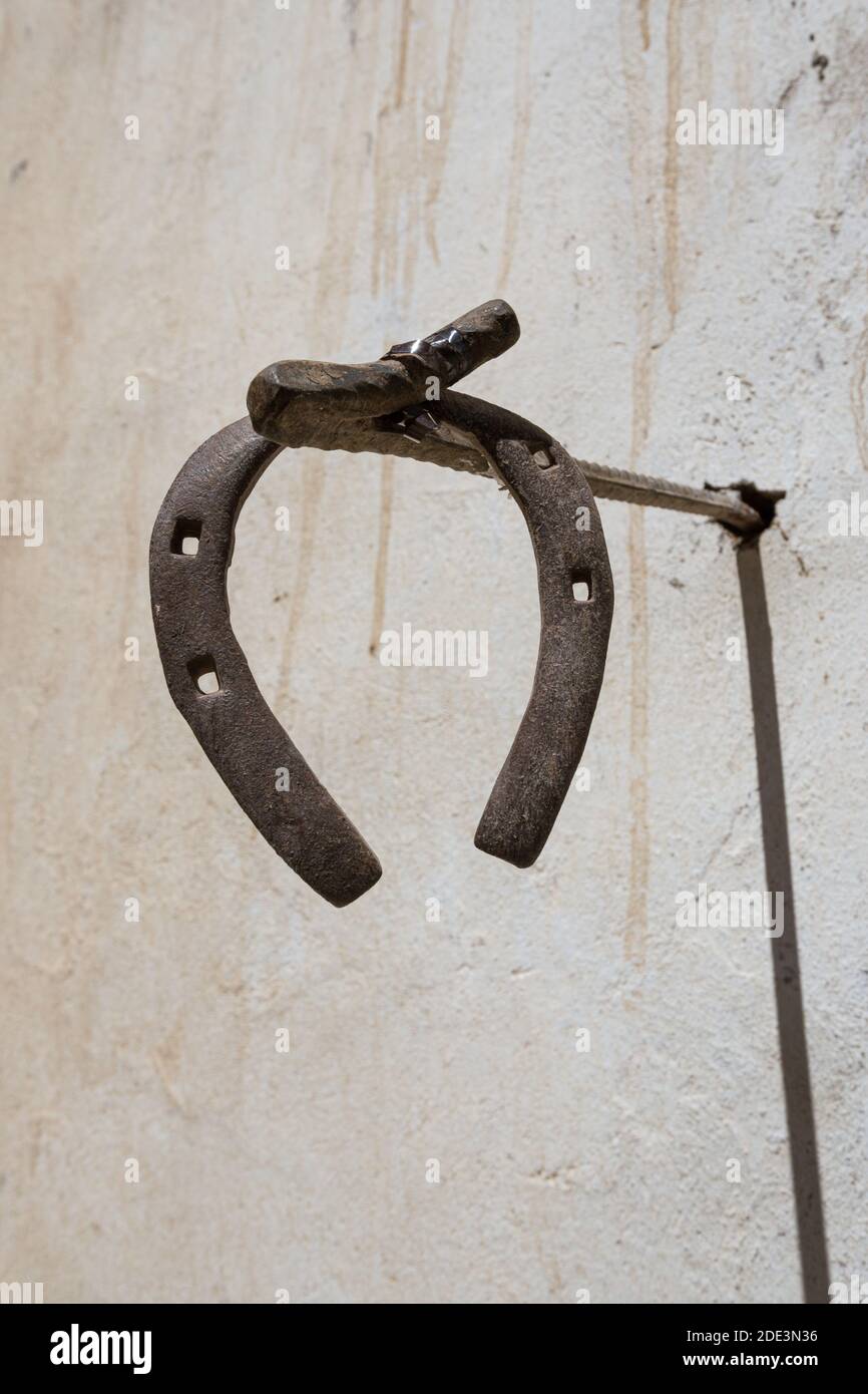 Horse shoe haning on the outside of a grey house Stock Photo
